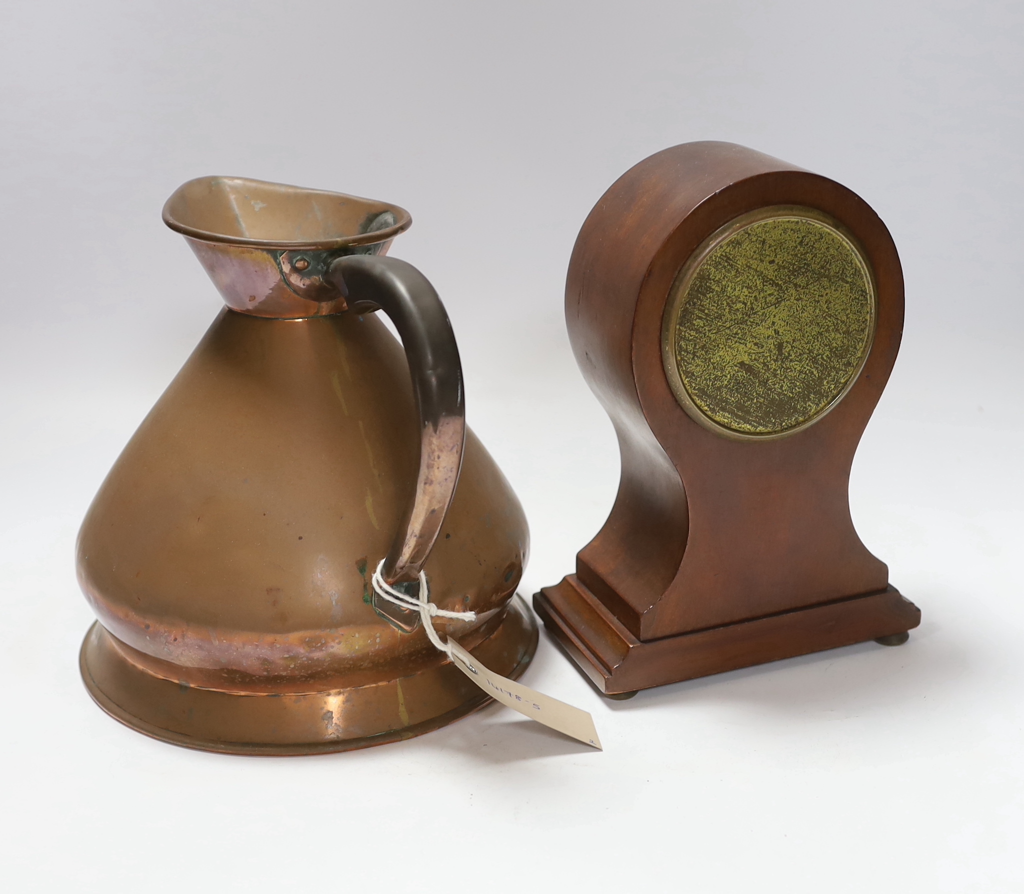A copper measure jug and a mantel clock